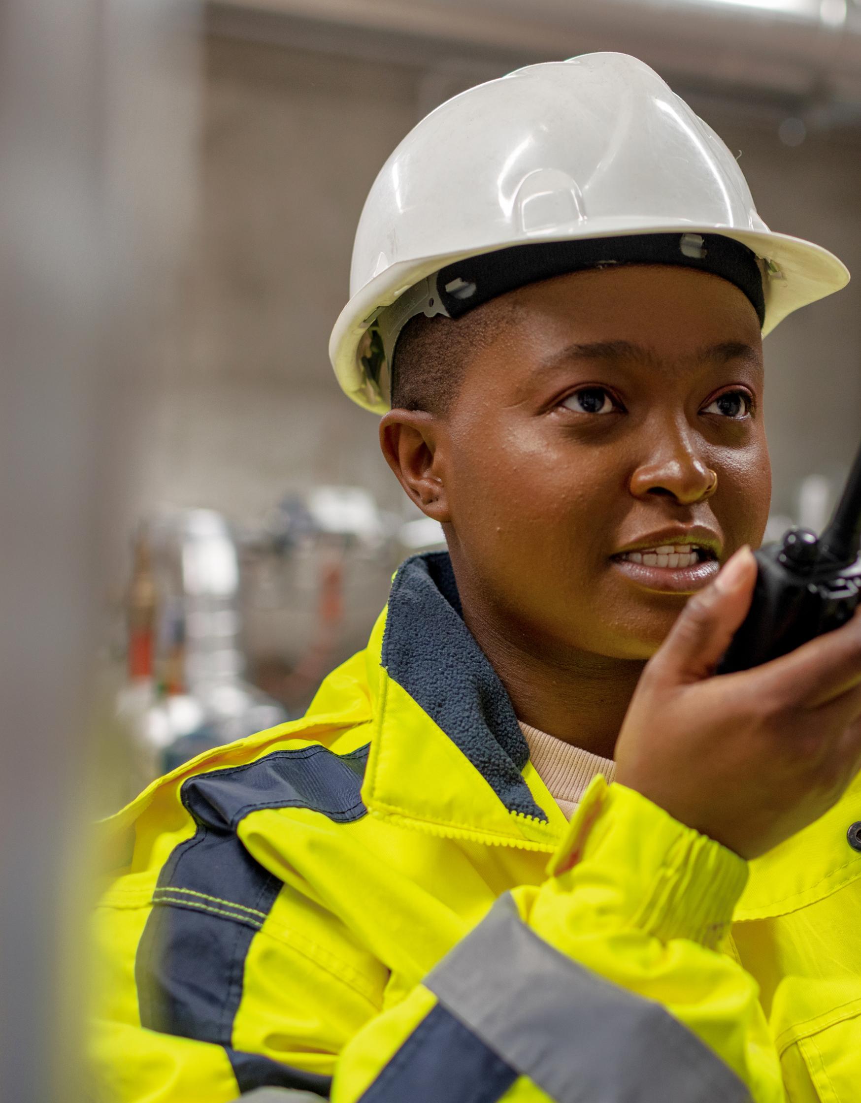 Female worker using walkie talkie to communicate.