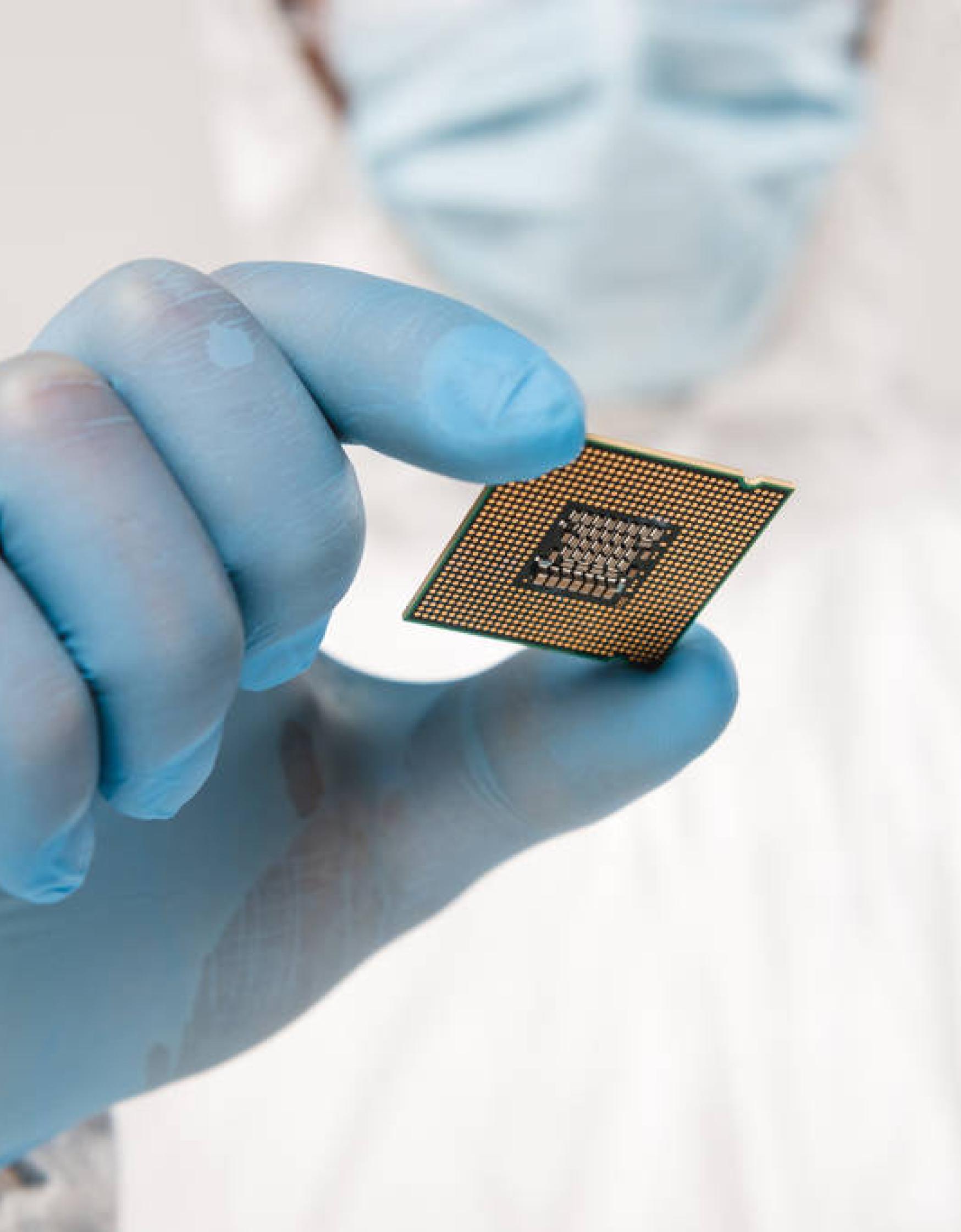 Focused hand of scientist holding a microprocessor.