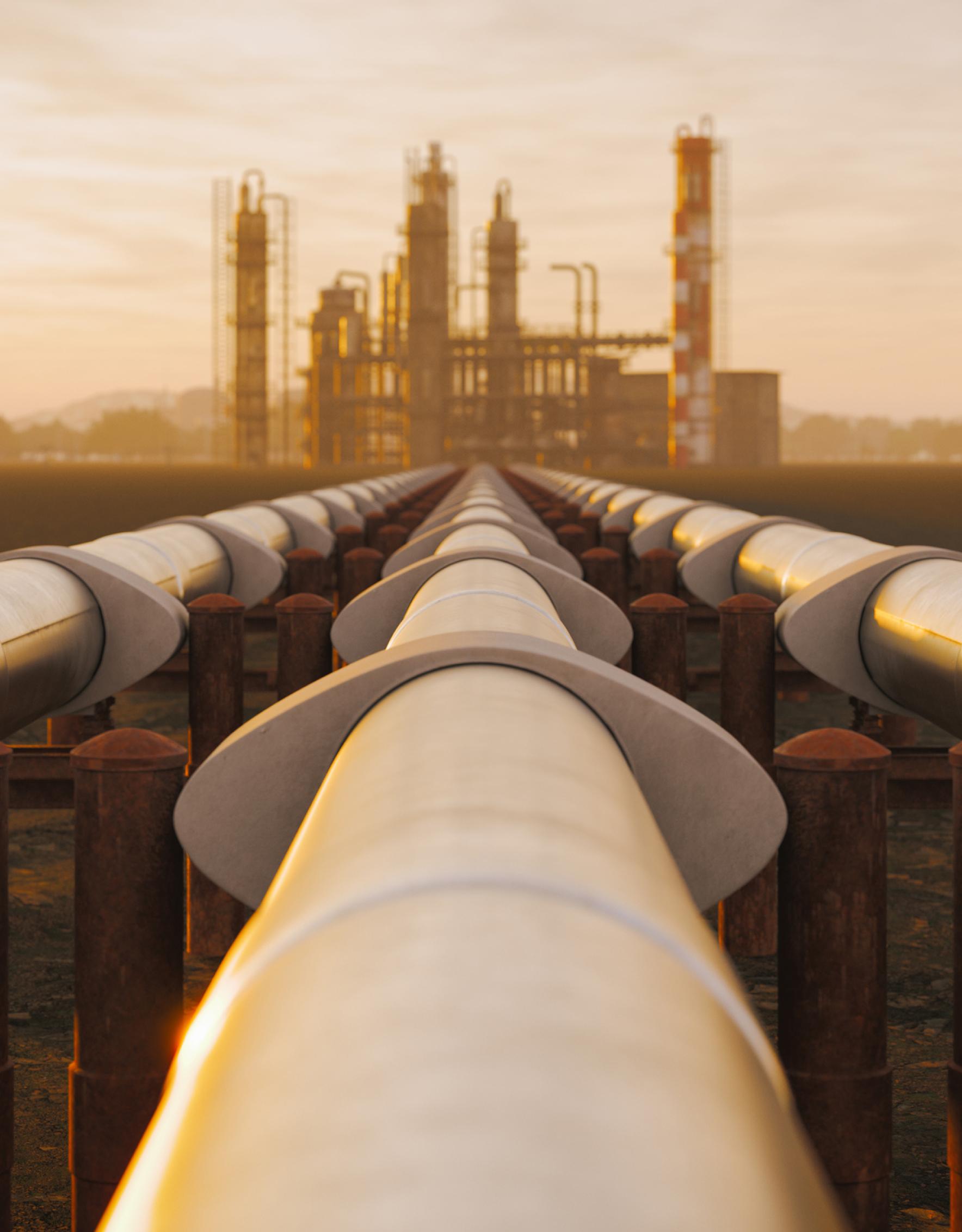 Tubos de aceite de acero de la refinería en el desierto durante la puesta de sol.