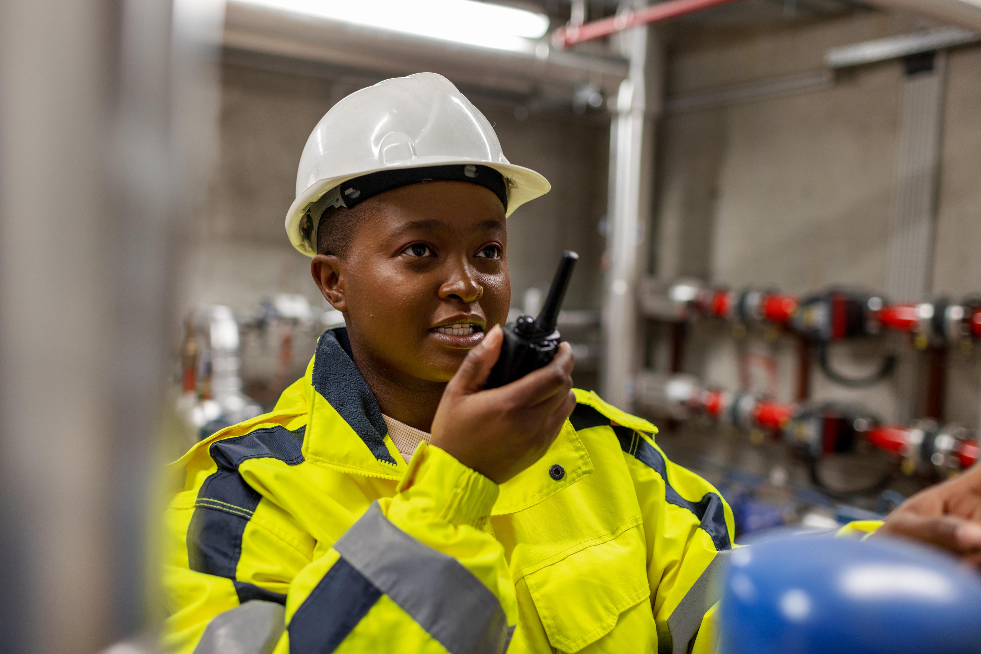 Female worker using walkie talkie to communicate