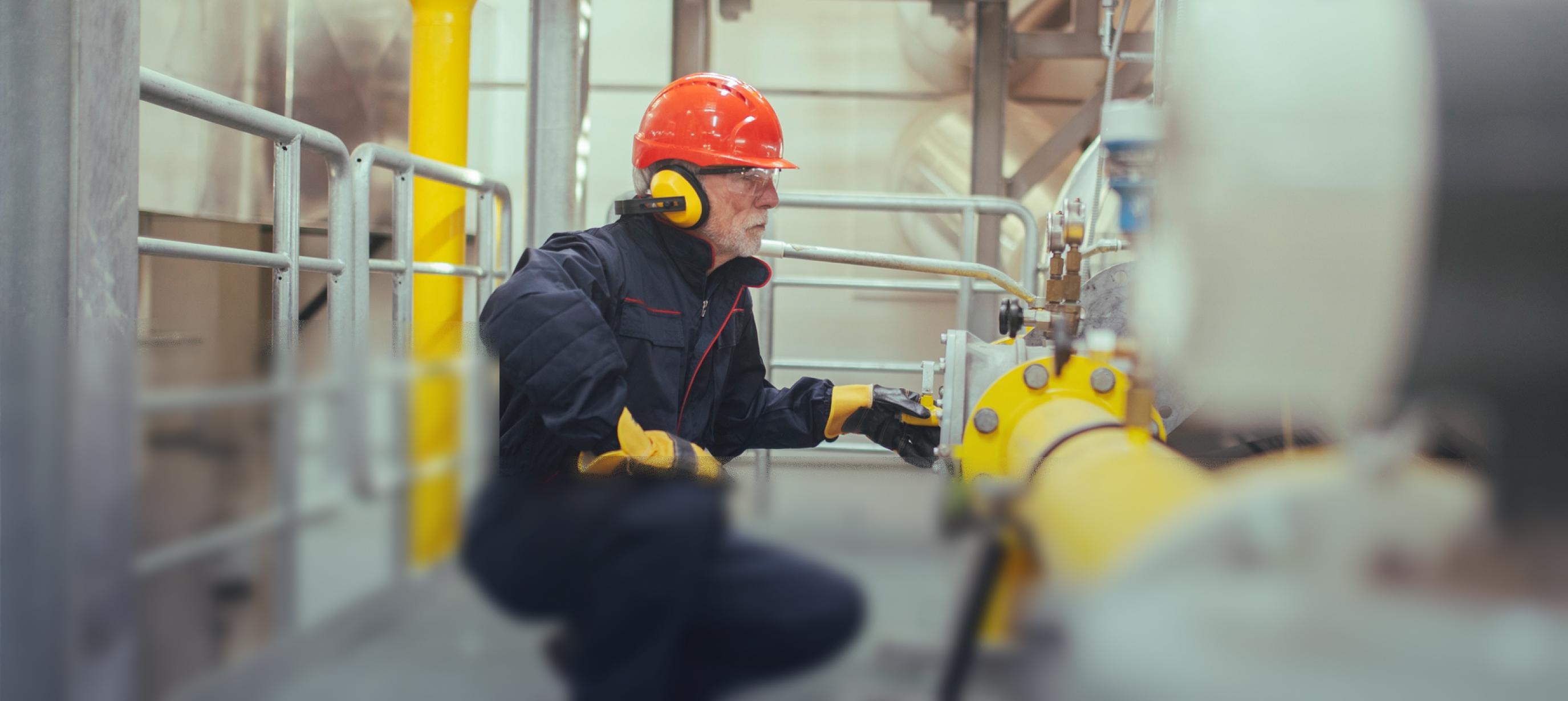 Personnel engineer, male worker, in the factory plant that operates the gas production machine