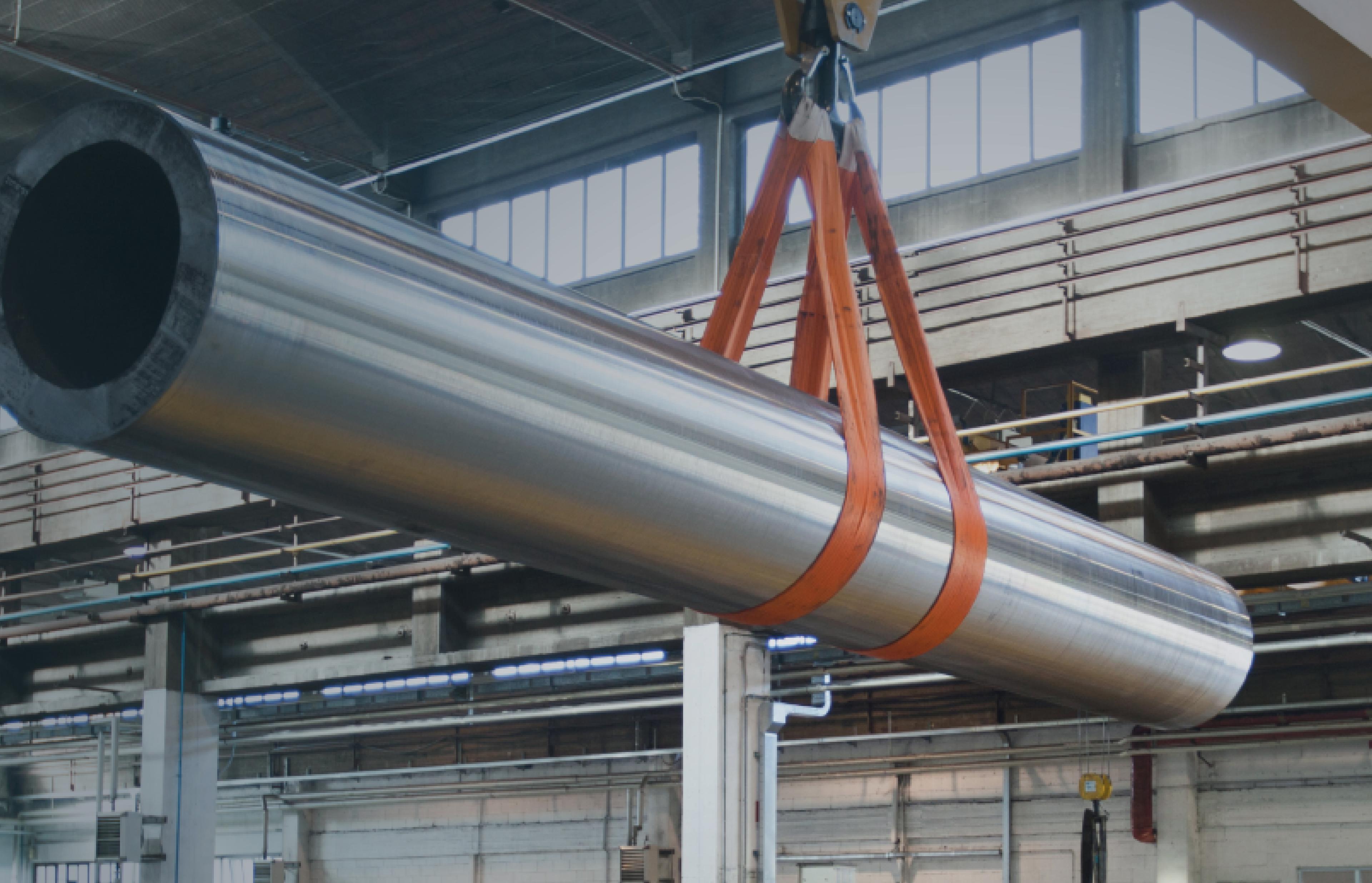 A steel pipe being lifted off the ground